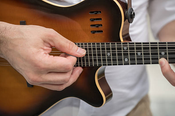 a person playing a Godin A8 electric mandolin. This is an 8-string mandolin,
