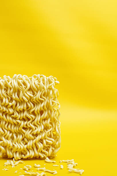 istock Raw instant noodles block on yellow background 2244236452
