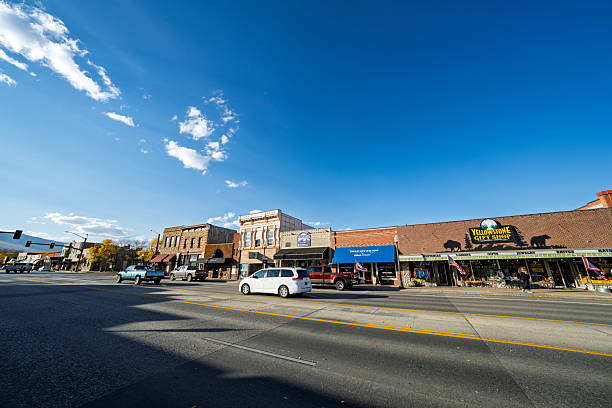 Cody, Wyoming, United States – October 2024: View of the main street in downtown Cody illuminated by the warm colors of sunset. Cars and storefronts line the road, representing the quiet rhythm of daily life in this historic western town near Yellowstone National Park.