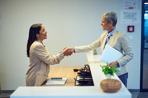 istock Businesswomen shaking hands at a reception desk 2244236928