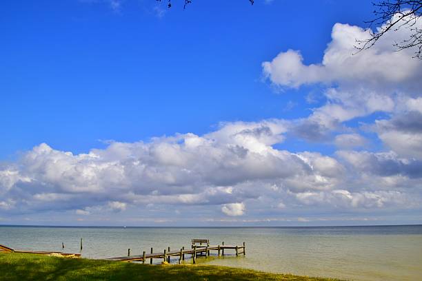istock Cumulus clouds in a bright blue sky over Chesapeake Bay and piers 2244237088