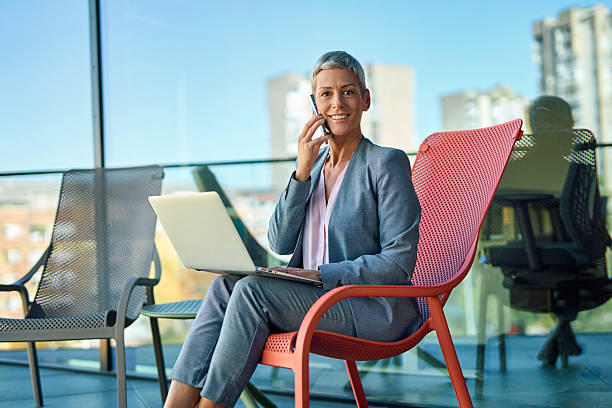 istock Businesswoman talking on phone and working on laptop 2244237100