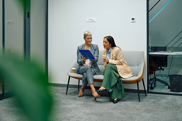istock Businesswomen discussing documents during coffee break in office 2244237119