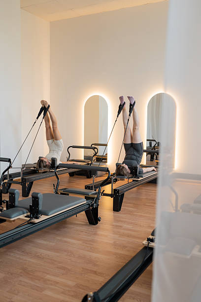 istock Peaceful reformer studio with natural light, Calm Pilates space featuring warm lighting and wooden 2244240510