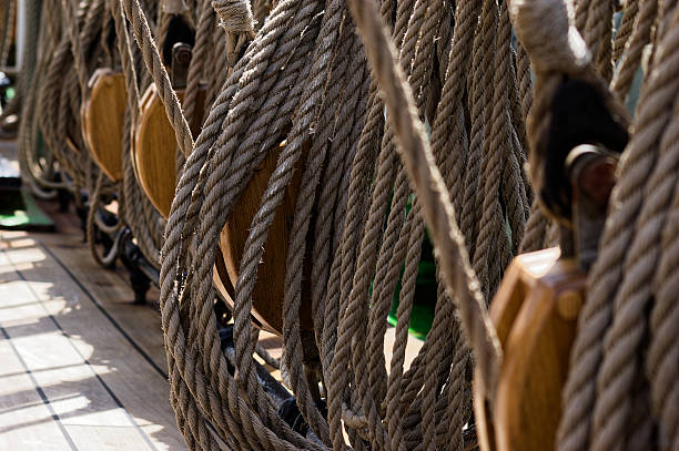 istock Weathered Ropes and Wooden Spools Stacked on Ship Deck 2244241522