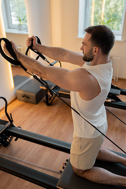 istock Kneeling pulley exercise, practicing on reformer pulley row focusing on shoulder control 2244241698