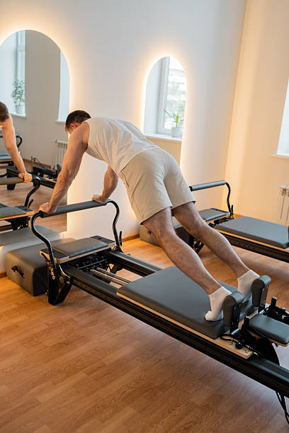 istock Dynamic reformer plank, individual executes dynamic plank with tension on reformer for endurance 2244241958