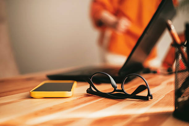 istock Workspace setup featuring glasses and smartphone in a minimalistic environment during daytime 2244246110
