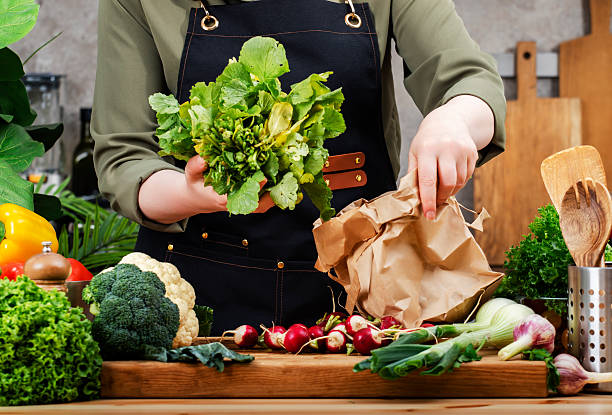 istock Chef works in kitchen, arranging fresh vegetables and herbs on wooden cutting board for healthy meal preparation 2244246162