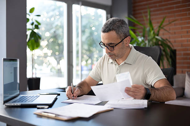 istock Man reviewing financial documents at home 2244247236