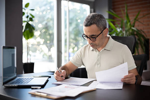 istock Man reviewing financial documents at home 2244247354