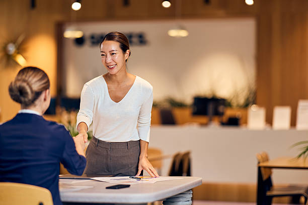 istock Asian Woman Greets Colleague With Friendly Handshake At Modern Office Reception During Business Meeting Setup 2244250024