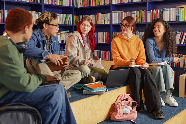 istock Group of Multiethnic Teenagers Studying Together in Modern Library Setting 2244252526