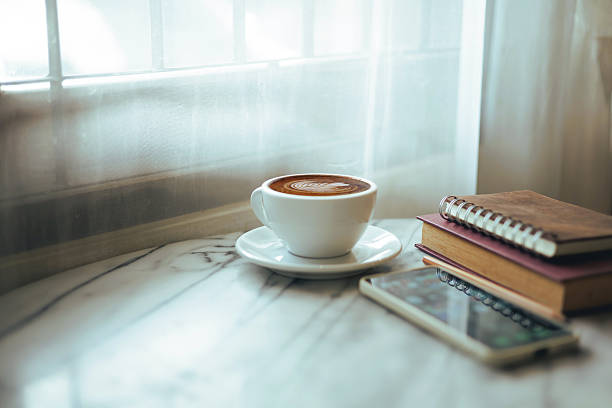 istock coffee drink, phone  and book on table 2244254619