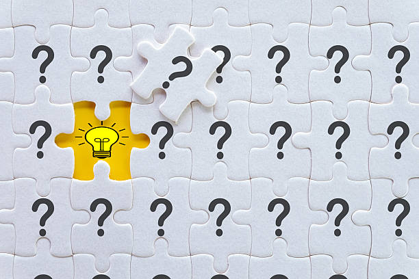 istock Finding the Solution: Lightbulb Idea Revealed by Missing Puzzle Piece among Questions 2244254810