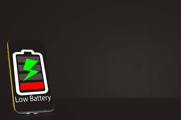 Smartphone with Low Battery icon on screen over black background with copyspace.