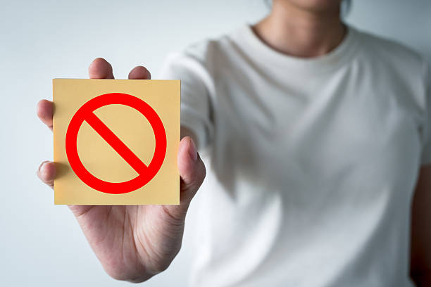 istock Rejection Concept: Person Holding Sticky Note with Red Prohibition Icon 2244255246