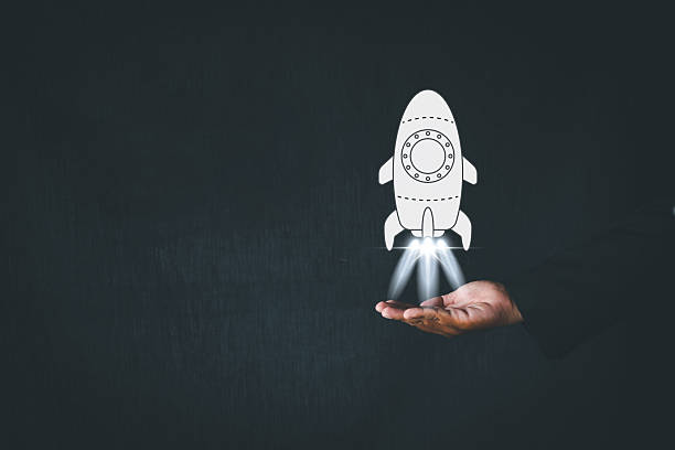 Startup Business,Creative idea,Motivation,Challenge or Goal Achievement in business concept.,Businessman flipping hand with rocket is launching icon over black background with copyspace use for business idea.