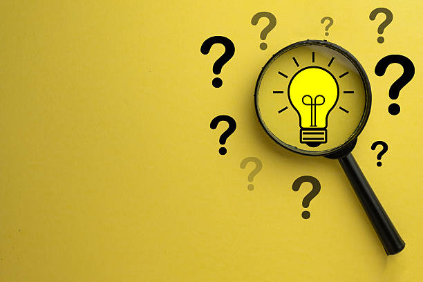 istock Finding the Solution: Magnifying Glass Focusing on Lightbulb Idea among Question Marks 2244256513