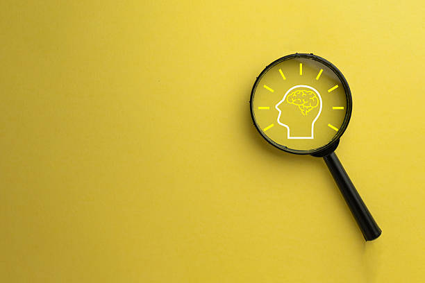 istock Focus on Brainstorming: Magnifying Glass over Glowing Brain Icon for Innovation 2244256697