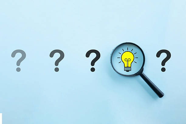 istock Finding the Solution: Magnifying Glass Focusing on Lightbulb Idea among Question Marks 2244256712