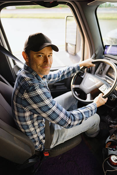 istock Truck Driver Smiling and Holding Steering Wheel 2244258219