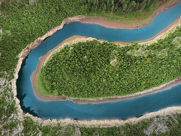 istock Aerial view showing a natural river meander winding through a dense forest, surrounded by dry riverbanks 2244258870