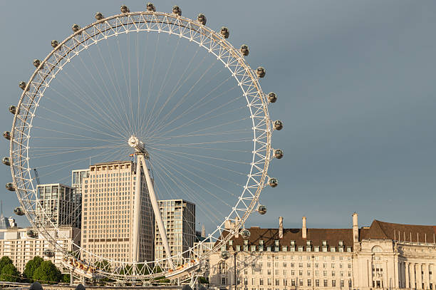 View of the London eye in the centre of London, UK.  People can be seen on the promenade