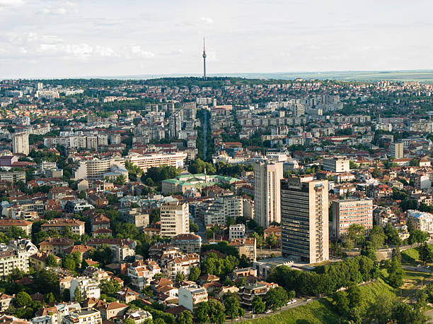 Establishing shot of middle sized green city landscape with lots of trees & parks. Drone view over sustainable eco walkable city in Europe. Carbon neutrality.