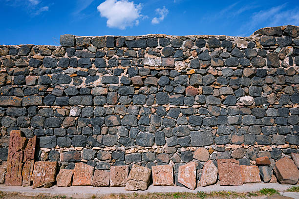 A wall made of stone blocks with a blue sky in the background. The wall is very tall and has a lot of space between the blocks
