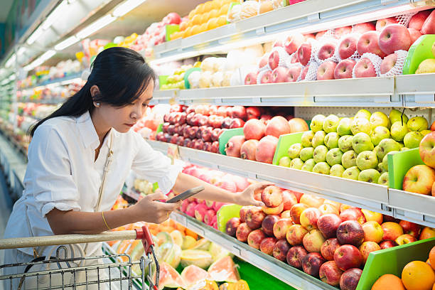 istock Woman comparing fruit prices using smartphone in supermarket 2244262244