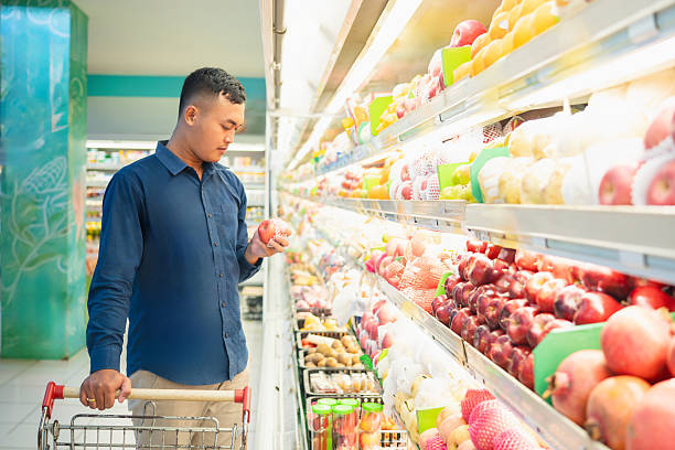 istock Man shopping for fresh fruit in supermarket aisle 2244262414