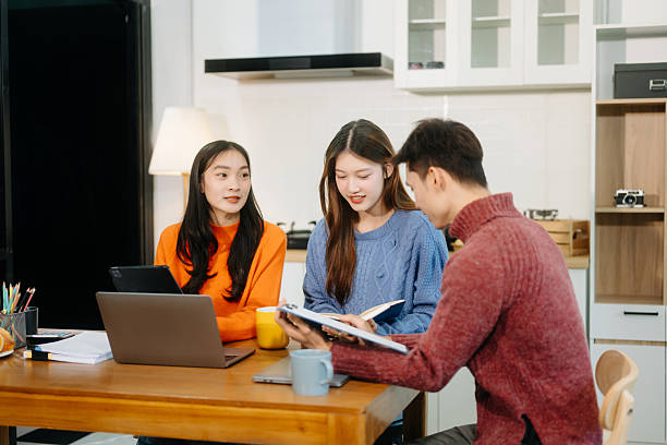 istock Teamwork and creativity with young adults collaborating on laptops and tablets in a cozy workspace. 2244263401