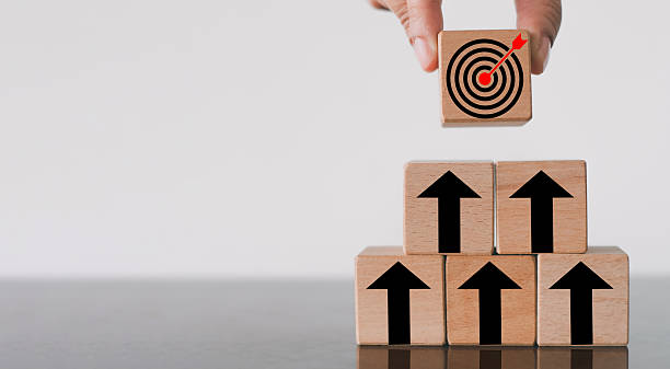 istock Business Growth to Goal: Hand Stacking Target Icon Block on Arrow Pyramid for Success Strategy 2244263567