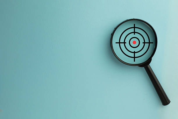 istock Focus on Goal: Magnifying Glass over Target Icon for Business Strategy on Blue Background 2244263583