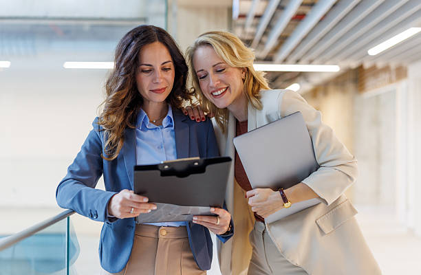 istock Businesswomen discussing documents in modern office building 2244267528