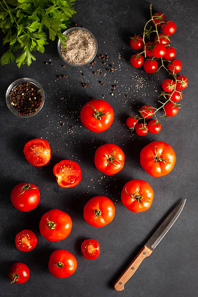 istock Fresh Tomatoes with Herbs, Salt, and Pepper on Dark Background 2244267697