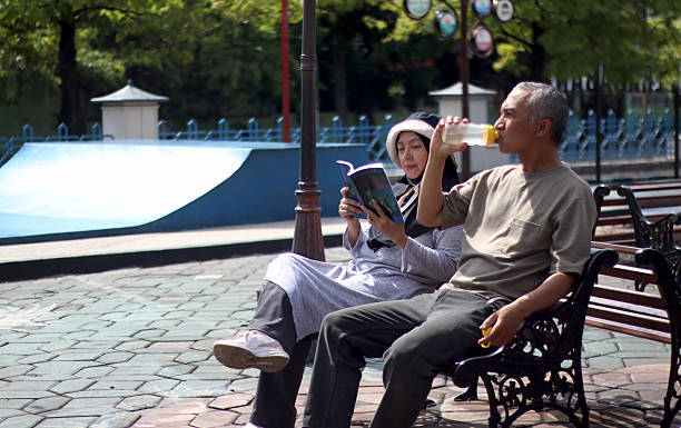 Mature man and woman reading the news outdoors shot with tilt and shift lens