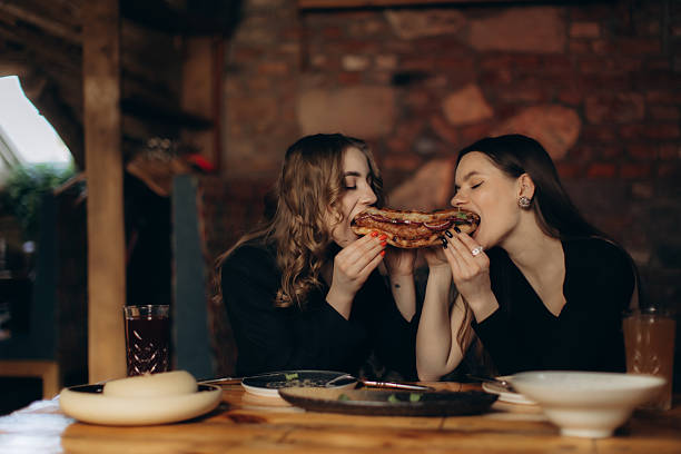 istock Two Friends Enjoying a Meal Together at a Cozy Restaurant Table 2244271714