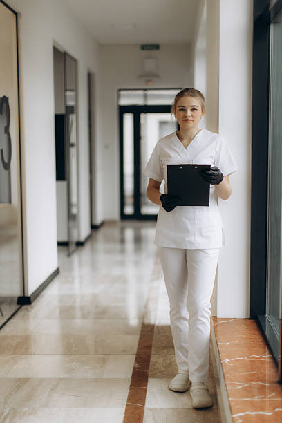 istock Professional Healthcare Worker Standing in Hallway Holding a Clipboard 2244272152