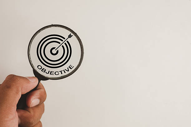 istock Hand holding magnifying glass focusing on a business objective and target icon with copy space. 2244272974