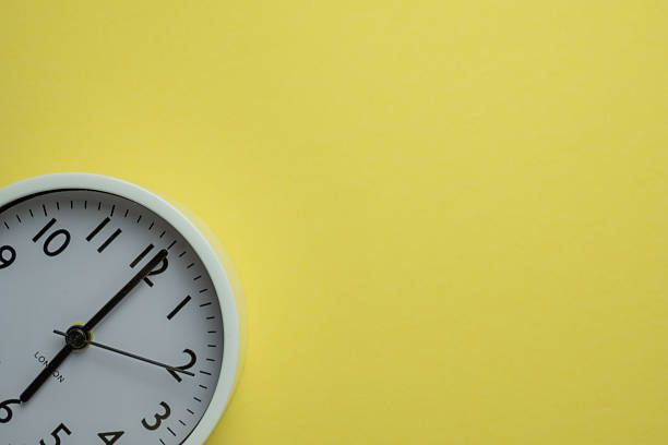 istock White clock (flat lay) on a bright yellow background with copy space, concept of time and deadlines. 2244273235