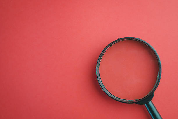 istock Magnifying glass on red background with copy space, concept of search, risk, or error finding. 2244275554