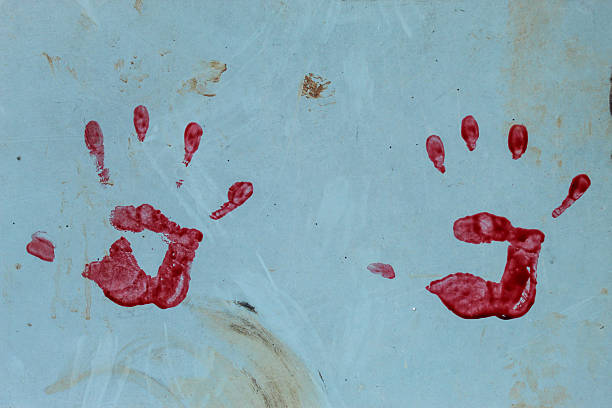 A red handprint on the wall surface. This handprint is clearly visible with detailed fingerprints and an imperfect palm shape.