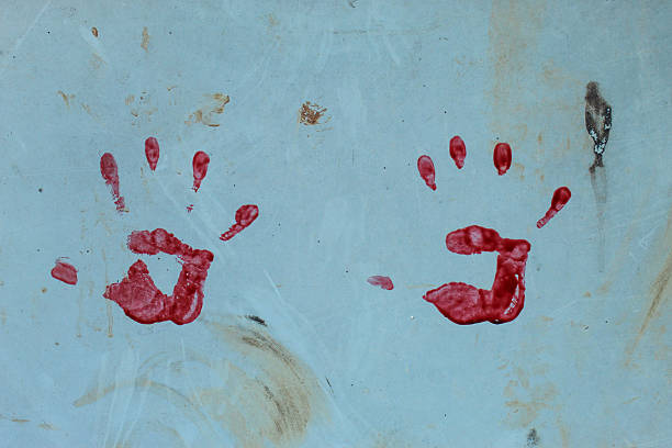 A red handprint on the wall surface. This handprint is clearly visible with detailed fingerprints and an imperfect palm shape.