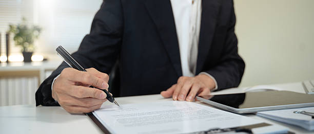 istock Closeup image businessman sitting at desk signing contract 2244277146