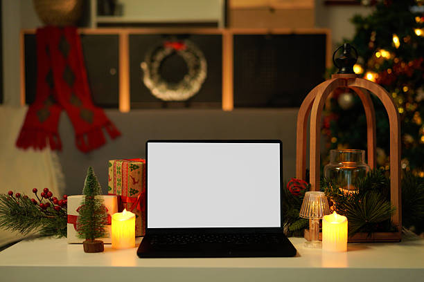 istock Blank display screen laptop computer on white wood table. Modern cozy comfortable home living room with Christmas decor. Home office desk workspace. 2244277381