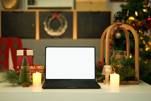 istock Blank display screen laptop computer on white wood table. Modern cozy comfortable home living room with Christmas decor. Home office desk workspace. 2244277383