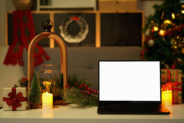 istock Front view of white screen laptop in home with Christmas tree warm light. Remote work. freelance. Work from home. Telework. 2244277385