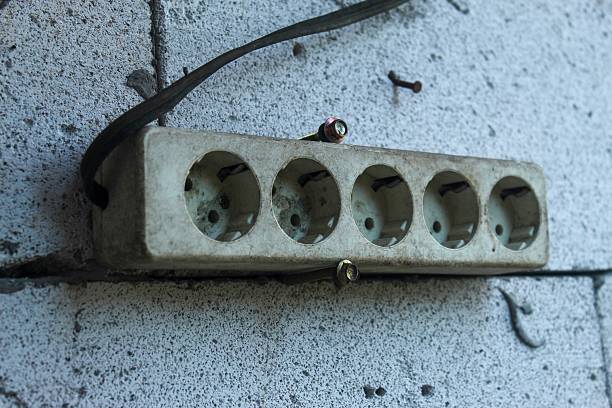 istock electrical plug or socket terminal with five socket holes that look dirty and dusty, attached to a textured concrete wall 2244277389